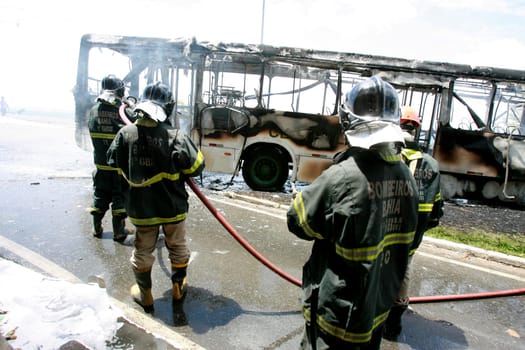 salvador, bahia / brazil - december 25, 2014: members of the fire brigade extinguish a fire on a public transport bus in the city of salvador.