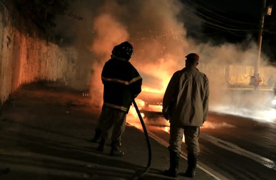 salvador, bahia / brazil - october 29, 2015: members of the fire brigade put out a fire in a vehicle in the city of salvador.