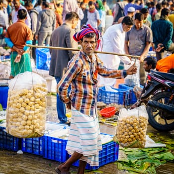 Chittagong, Bangladesh, December 23, 2017: Vendors with traditional bengali snacks at the crowded market near Karnaphuli River in Chittagong