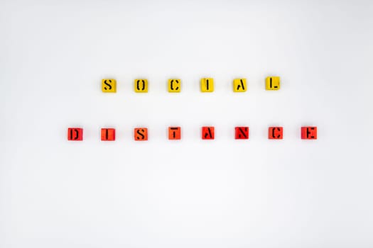 Yellow and red wooden cubes with message Social Distancing isolated on white background