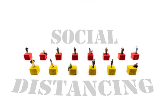 Miniature figurines standing on wooden cubes with message Social Distancing isolated over white background