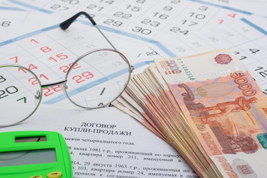 The purchase agreement contains a bundle of money, a calculator and glasses