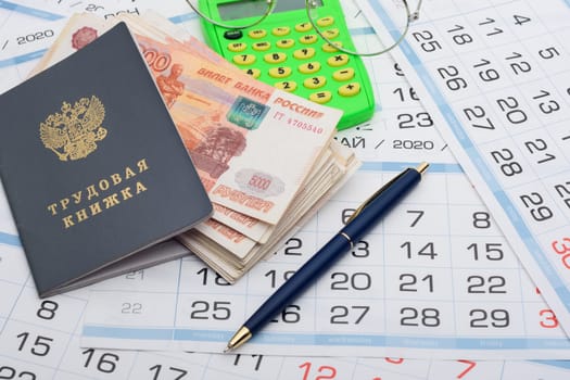 Labor retirement savings, work book, calendar, pen and glasses on calendar background