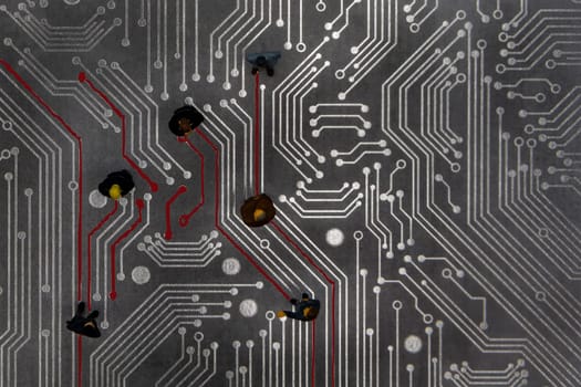 Miniature figurines posed as connected business people in a meeting over abstract futuristic circuit board, future business concept