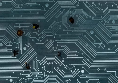 Miniature figurines posed as business people in a meeting over abstract futuristic circuit board, future business concept