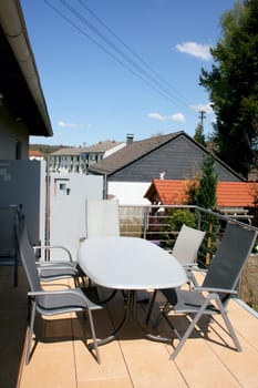 A terrace with stainless steel railings and beige floor tiles.