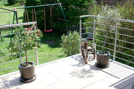 A terrace with stainless steel railings and beige floor tiles.