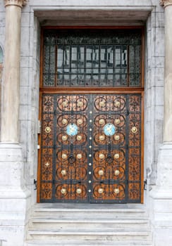 a front door with metal ornaments and wood ornaments.