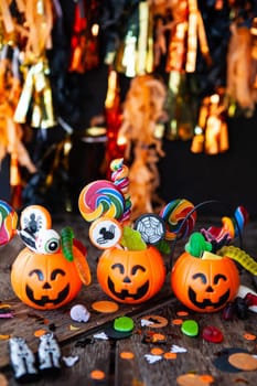 Colorful Halloween candy in little smiling pumpkin baskets