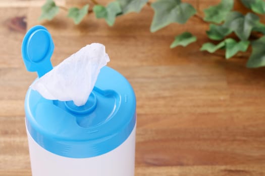 plastic tube shaped box of wet tissue paper on wooden table