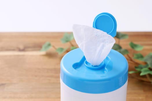 plastic tube shaped box of wet tissue paper on wooden table