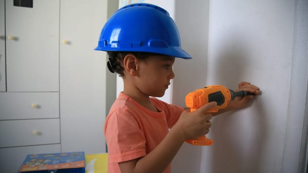 salvador, bahia / brazil - august 4, 2020: child wearing protective helmet plays construction.