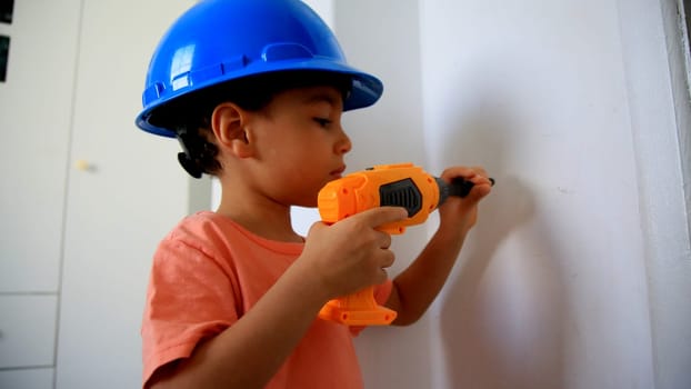 salvador, bahia / brazil - august 4, 2020: child wearing protective helmet plays construction.
