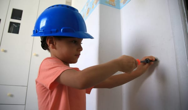 salvador, bahia / brazil - august 4, 2020: child wearing protective helmet plays construction.