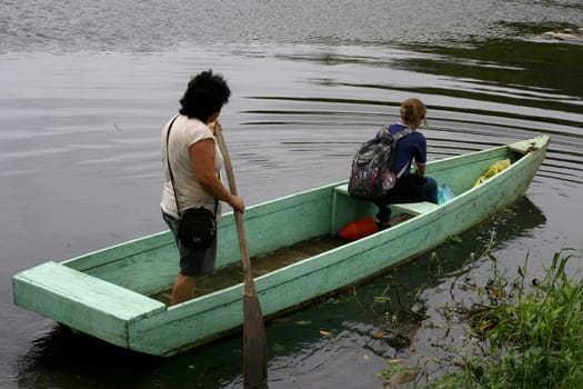 ilheus, bahia / brazil - june 20, 2011: woman is seen rowing a boat while crossing the Cachoeira river in the city of Ilheus, in the south of Bahia.