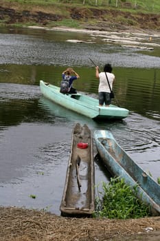 ilheus, bahia / brazil - june 20, 2011: woman is seen rowing a boat while crossing the Cachoeira river in the city of Ilheus, in the south of Bahia.