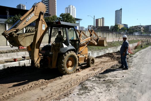 itabuna, bahia / brazil - december 9, 2011: machines and workers are seen during construction of Canal Lava Pes to drain the sewage network in the city of Itabuna, in southern Bahia.