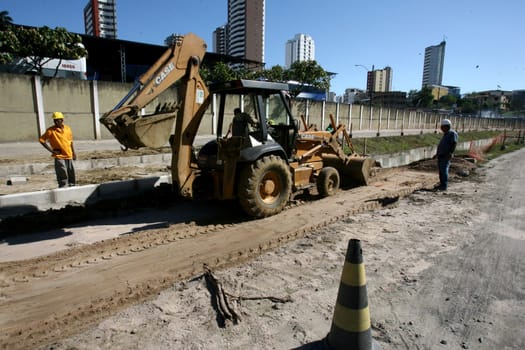 itabuna, bahia / brazil - december 9, 2011: machines and workers are seen during construction of Canal Lava Pes to drain the sewage network in the city of Itabuna, in southern Bahia.