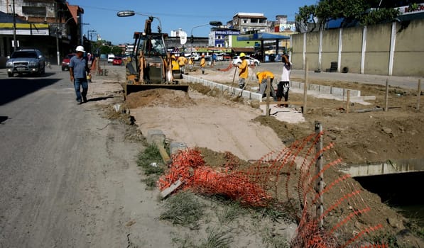 itabuna, bahia / brazil - december 9, 2011: machines and workers are seen during construction of Canal Lava Pes to drain the sewage network in the city of Itabuna, in southern Bahia.