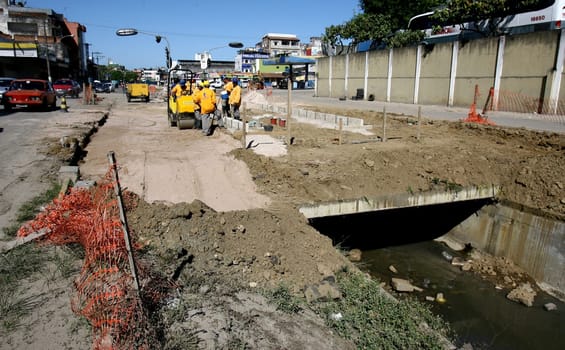 itabuna, bahia / brazil - december 9, 2011: machines and workers are seen during construction of Canal Lava Pes to drain the sewage network in the city of Itabuna, in southern Bahia.