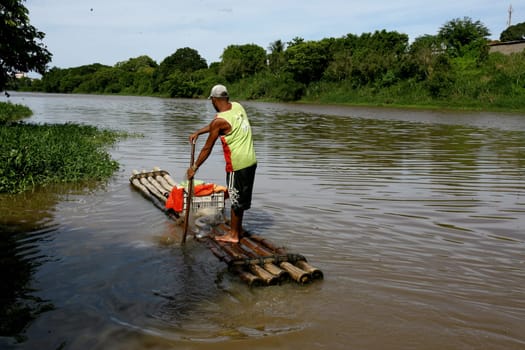 itabuna, bahia / brazil - december 20, 2011: fisherman is seen on a raft in the waters of the Cachoeira river in the city of Itabuna, southern Bahia.
