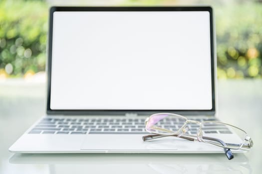 Eye glasses on laptop computer on table at home office