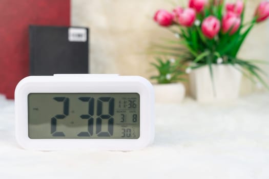 Close up Digital clock with book stacked on table