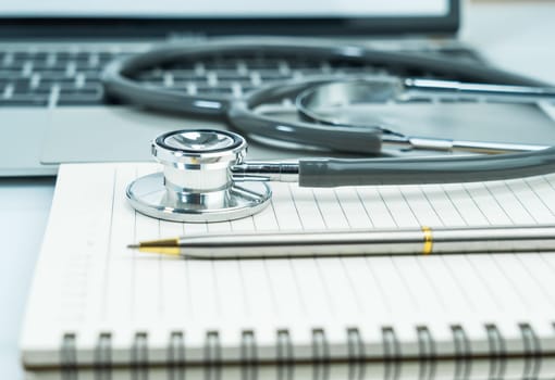 Medical stethoscope for doctor checkup on notepad as medical concept