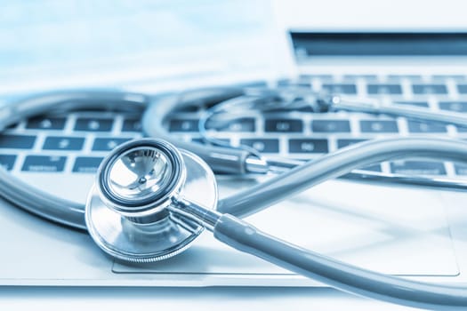 Medical stethoscope for doctor checkup on laptop with medical face masks as medical concept
