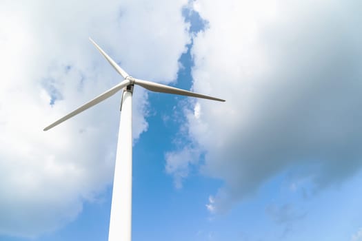 Close up Wind turbine  generators against a cloudy blue sky