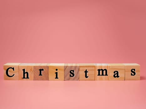 Christmas concept with wooden blocks on pink background. copy space.
