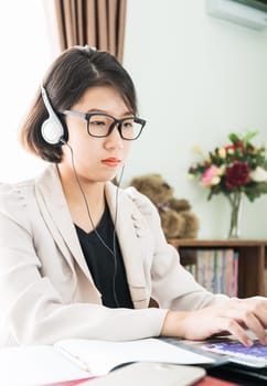 Teenage girl short hair in smart casual wear working on laptop while sit near window in home office