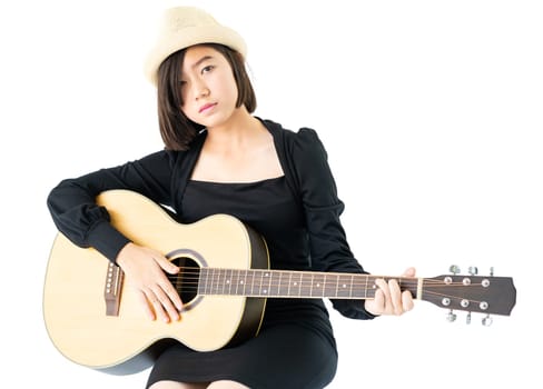 Young asia woman sitting and playing guitar guitar folk song in her hand isolate on white background