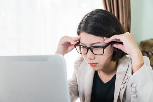 Woman teenage short hair in smart casual wear working on laptop while sit near window in home office