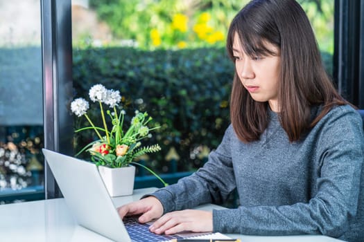 Young female using laptop for studying in open work place ,Young  female student using a laptop to do homework at home
