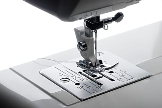 1 - Elevated close up view looking from the left hand side of the working area of a sewing machine.