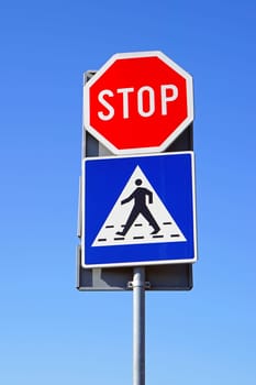 Stop sign and pedestrian crossing at traffic pole