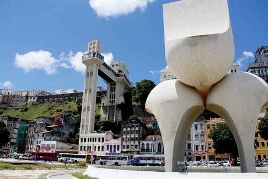 salvador, bahia / brazil - march 21, 2013: sculpture by Mario Cravo in the Comercio neighborhood and in the background the Lacerda Elevator in the city of Salvador.
