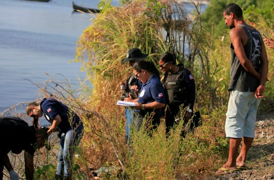 salvador, bahia / brazil - november 23, 2015: civil police investigators are investigating a murdered person near the suburban train line in the city of Salvador.