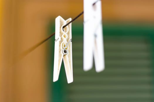 a white plastic clothespin hanging. housework and laundry