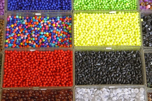 Various colorful plastic beads in trays