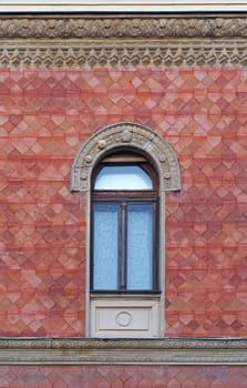 Arch window at classic style building with red facade