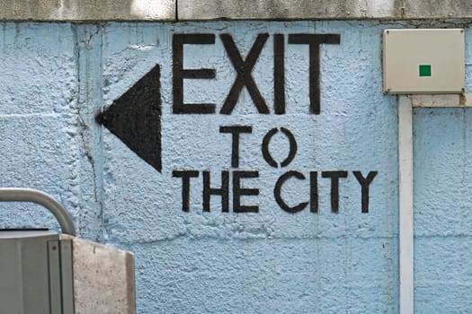 Exit to the city sign with arrow at wall