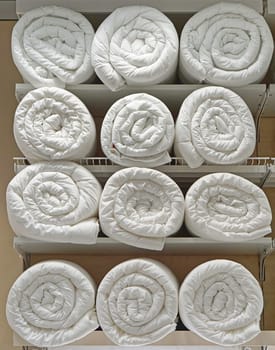 Many clean white duvets blankets in rolls