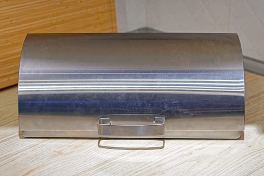 Closed stainless steel bread box at kitchen countertop