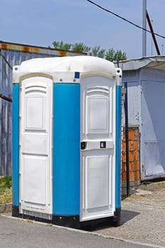 Portable toilet cabin at open construction site