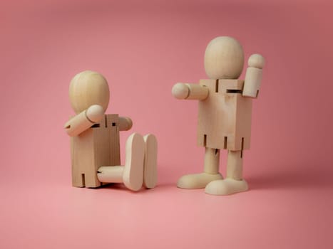 2 wooden dolls sitting and standing Talk gestures On the pink background..Concept of social contact from wood dolls..
