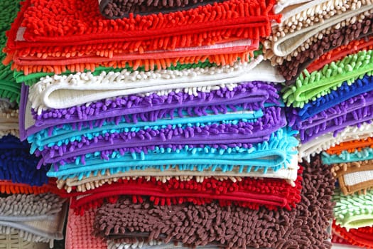 Pile of colorful bathroom rugs and floor mats