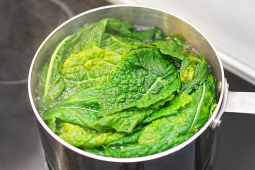 Cooking leafy green swiss chard in pot