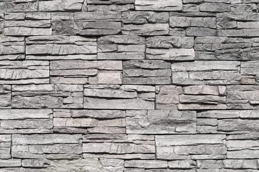 Grey stone tiles with rough surface at house wall